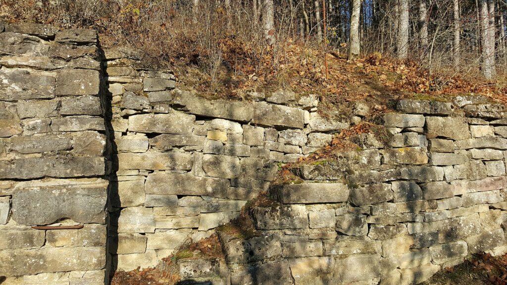 Gemauerte Natursteinmauer aus Kalkstein im Sonnenlicht